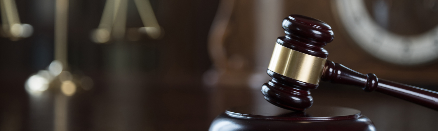 Gavel Foreground with Blurred Scales of Justice in Background