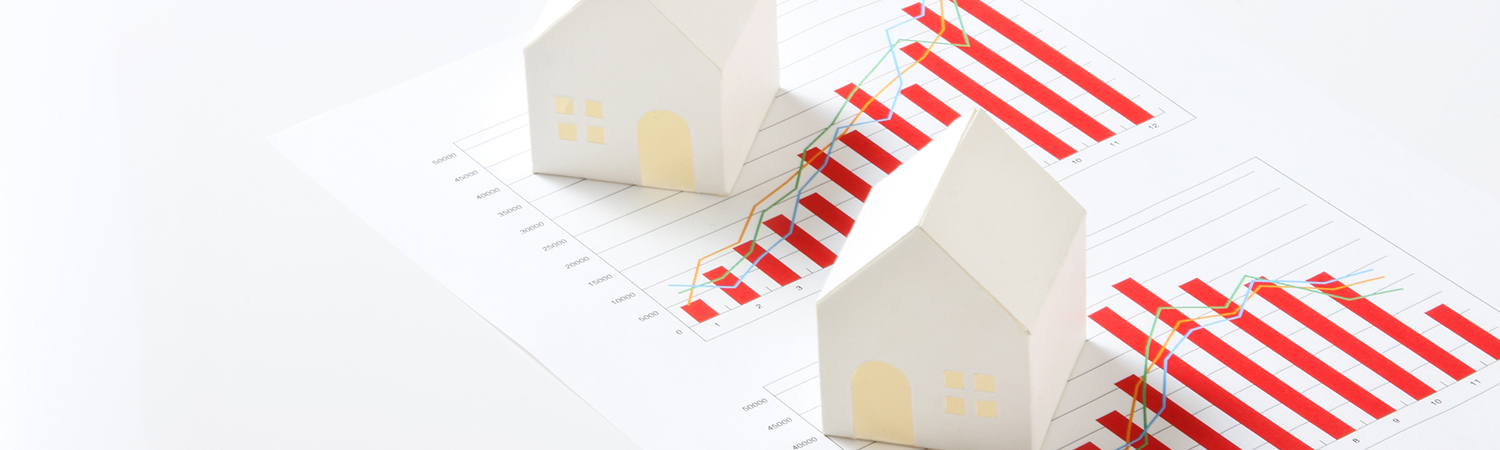White Model Houses Placed on a Printout of Charts